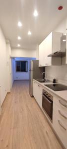 a kitchen with white cabinets and a wooden floor at Portonaccio suite - Stazione Tiburtina - Università - Metro B in Rome