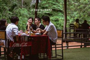 un groupe de personnes assises à une table dans l'établissement Chiewlan Camp and Resort, à Ban Pha Saeng Lang