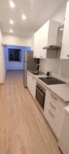 a kitchen with white cabinets and a wooden floor at Portonaccio suite - Stazione Tiburtina - Università - Metro B in Rome