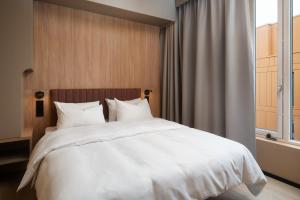 a bedroom with a large white bed with a window at Skaret by Vander in Tromsø