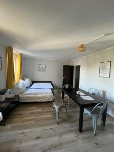 1 dormitorio con 1 cama, mesa y sillas en Bayern Lodge München, en Múnich