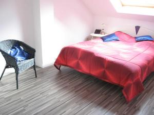 een slaapkamer met een groot rood bed en een stoel bij Ferienwohnung Stoetera in Malente