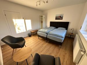 a bedroom with a bed and a chair and a table at Apartment Fernsicht in Borgarnes