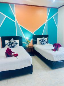 - une chambre avec 2 lits avec des roses dans l'établissement Lanta Grand House, à Ko Lanta