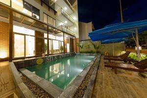uma piscina no meio de um edifício em Silk and Sea Hotel em Hoi An