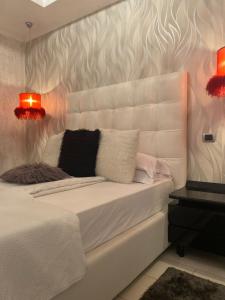 um quarto com uma cama branca com duas almofadas em Central Luxury Apartament Nr 5 ***** em Bucareste