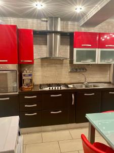 uma cozinha com armários vermelhos e um lavatório em Central Luxury Apartament Nr 5 ***** em Bucareste