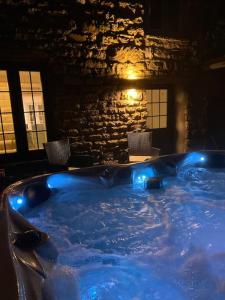 a hot tub with blue lights in a room at Rural 5* Rookby Cottage, with large Hot Tub in Winton