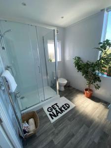 a bathroom with a shower and a sign that says go ninja at Santiago Suite 3 - A Stylish Southport Apartment in Southport
