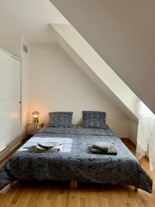 a bedroom with a large bed with blue pillows at La Mandragora - Maison avec jardin et poêle à bois in Vernon