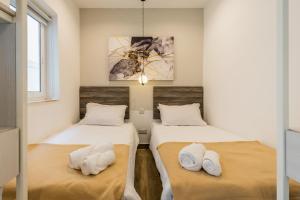 two beds in a room with white pillows at room 34- with kitchenette at the new Olo Living by SF Homes in Paceville
