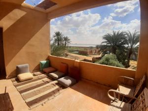a balcony with a view of the desert and palm trees at M Biama Island in Siwa