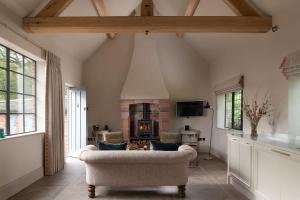 a living room with a couch and a fireplace at Blacksmith's Cottage in Nantwich