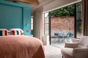 a bedroom with a bed and a table and chairs at Blacksmith's Cottage in Nantwich