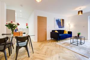 a living room with a blue couch and a table at Hybrid Resi - Mitcham close to Tooting and Wimbledon in Mitcham