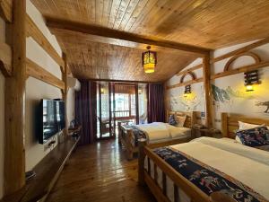 张家界Mountain View Guesthouse的一间有两张床和一台电视的酒店房间