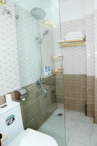 y baño con ducha de cristal y aseo. en Luxury Airport Hotel Travel en Noi Bai