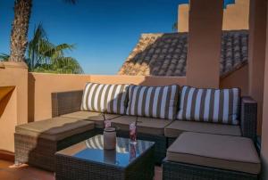 d'une terrasse avec un canapé et une table. dans l'établissement Pure Beach Penthouse & Swimming pool, 3 bedrooms, à Los Alcázares