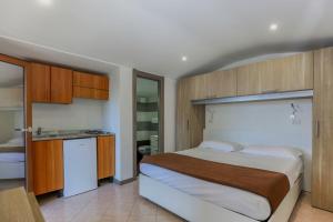 a bedroom with a large bed and a kitchen at Village Camping Santa Fortunata - Campogaio in Sorrento