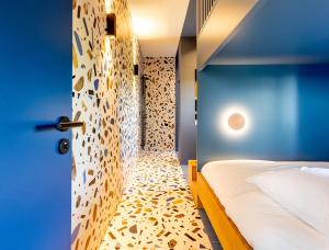 1 dormitorio con cama y pared azul en Kindadom - Maison pour vacances insolites et inoubliables en Belgique, en Montzen