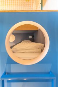 uma cama num pequeno quarto com um espelho redondo em Kindadom - Maison pour vacances insolites et inoubliables en Belgique em Montzen