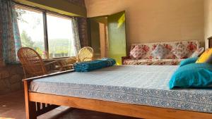 a bedroom with a bed with blue sheets and a window at Thendral: Delightful homestay on a hill near Ooty in Naduvattam