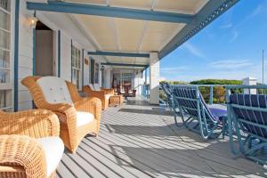 a porch with chairs and wicker furniture on a house at Atlantic Dream Beachfront Villa in Scarborough