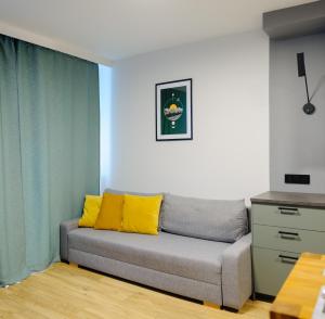 a couch with yellow pillows in a living room at Like Home Apartments in Kraków