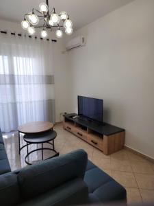 een woonkamer met een bank, een tafel en een tv bij Durres Center in Durrës