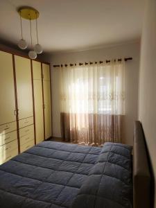 a bedroom with a bed and a dresser and a window at Durres Center in Durrës
