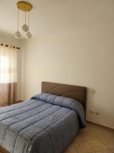 - une chambre avec un grand lit et une couverture bleue dans l'établissement Durres Center, à Durrës
