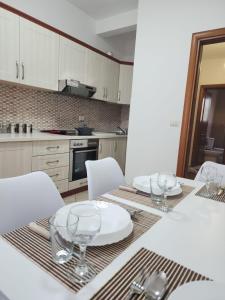 een keuken met een tafel met borden en glazen erop bij Durres Center in Durrës
