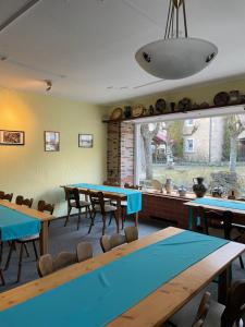 a room with tables and chairs and a large window at Schwarze Adler in Streitberg