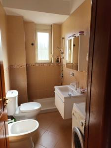 een badkamer met een toilet, een wastafel en een spiegel bij Durres Center in Durrës