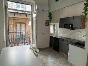 a kitchen with a white counter top and a table at Palermo Wow - Aragona in Palermo