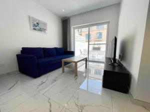 un soggiorno con divano blu e tavolo di Brooklyn Apartments Sliema a Sliema