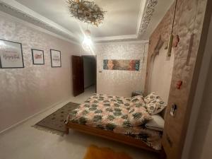 a bedroom with a bed and a chandelier at Villa Koebi in Monte ʼArrouit