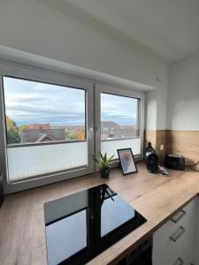 uma secretária com duas janelas grandes num quarto em BnB Open Apartments Pader-Stars em Paderborn