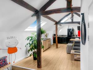 una sala de estar de planta abierta con vigas de madera y una sala de estar. en Le Jardin de Bannier en Orléans