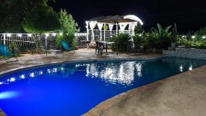 a swimming pool at night with a table and an umbrella at Koi Inn in Hartbeespoort
