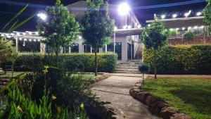 un jardín por la noche con una casa con luces en Koi Inn, en Hartbeespoort