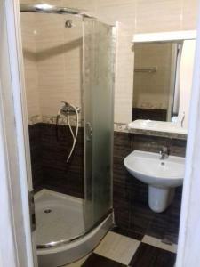 un bagno con doccia e lavandino di Ametist a Mukačevo Altre 11 foto
