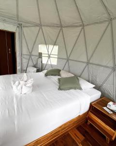 a bedroom with a large white bed in a yurt at Rimwa Riwa Camp in Ban Huai Mi