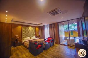 a bedroom with a bed and a chair and a television at Aswadduma Hotel in Dambulla