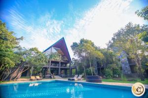 a swimming pool in front of a building at Aswadduma Hotel in Dambulla