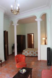 Habitación de hotel con cama y silla roja en Hotel Rey Niño, en Ávila