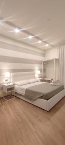 a white bedroom with a large bed and two tables at Portonaccio suite - Stazione Tiburtina - Università - Metro B in Rome