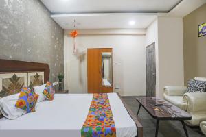 1 dormitorio con cama, sofá y mesa en FabHotel Classic Stay Inn, en Nagpur