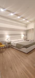 a white bedroom with a large bed and a chair at Portonaccio suite - Stazione Tiburtina - Università - Metro B in Rome