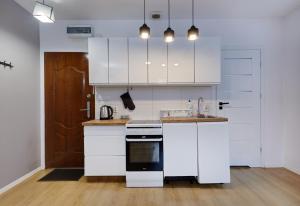 a kitchen with white cabinets and a stove top oven at Crystal Apartment Katowice VI in Katowice +6 photos